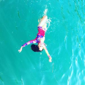 alooppa wetsuit, model in blue water